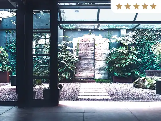 Entrada con jardín vertical, plantas de sombra y camino de piedra