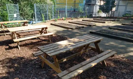 Huerto escolar terminado en Badalona, con bancales y mesas de picnic