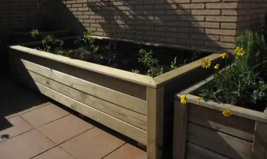 Bancales de madera altos recién plantados en una terraza